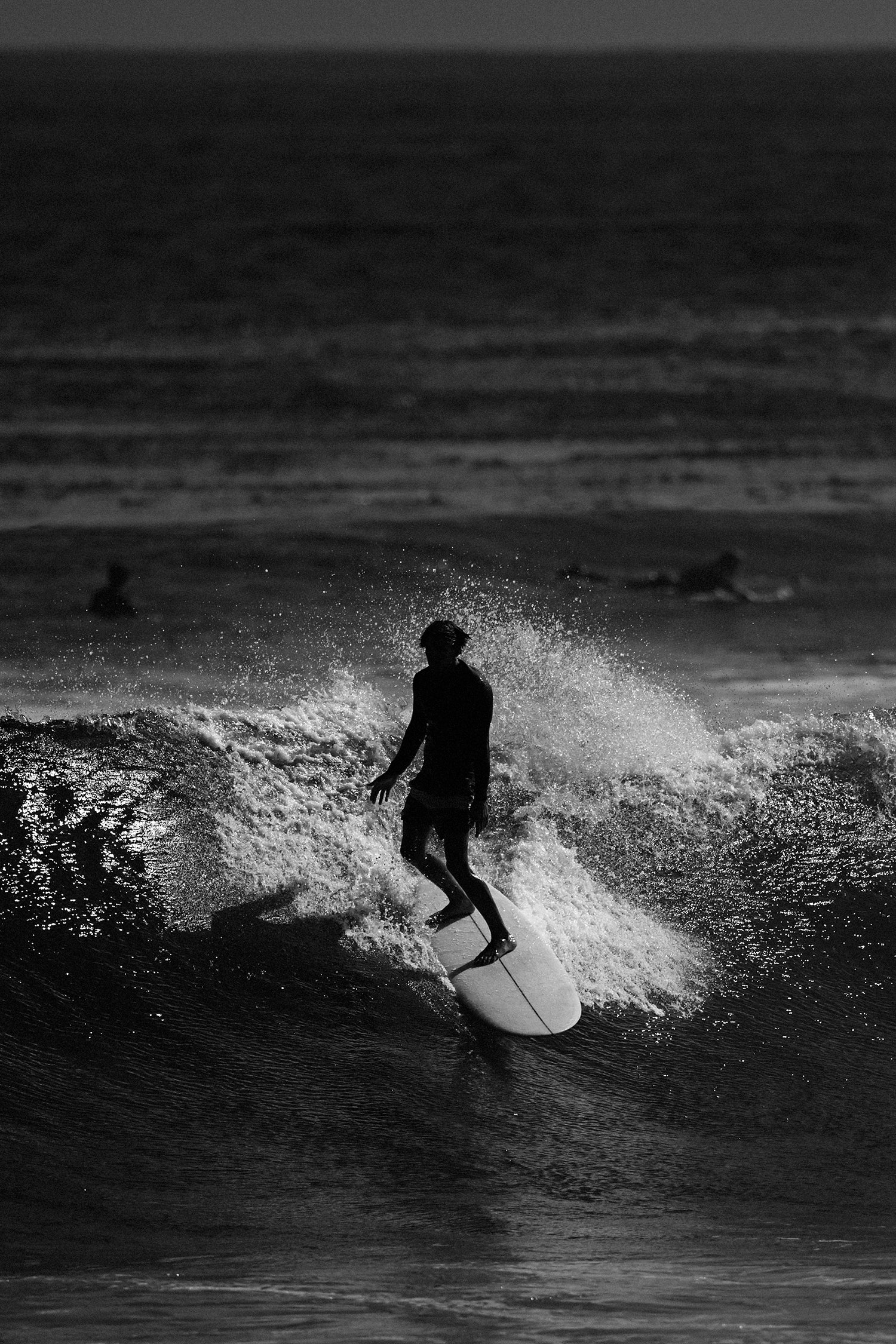 Person surfing on a wave in black and white