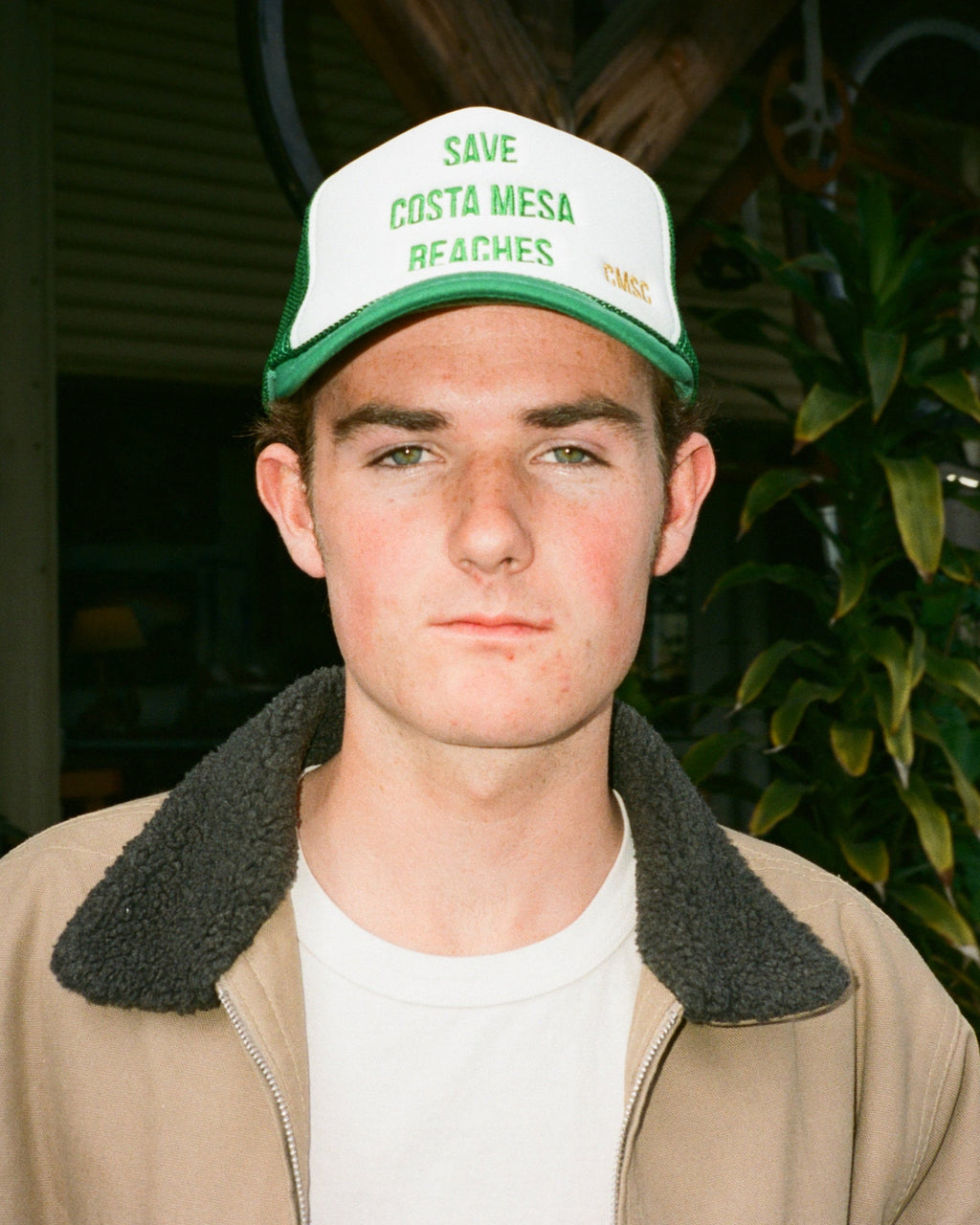 Person wearing a cap with 'Save Costa Mesa Beaches' text outdoors
